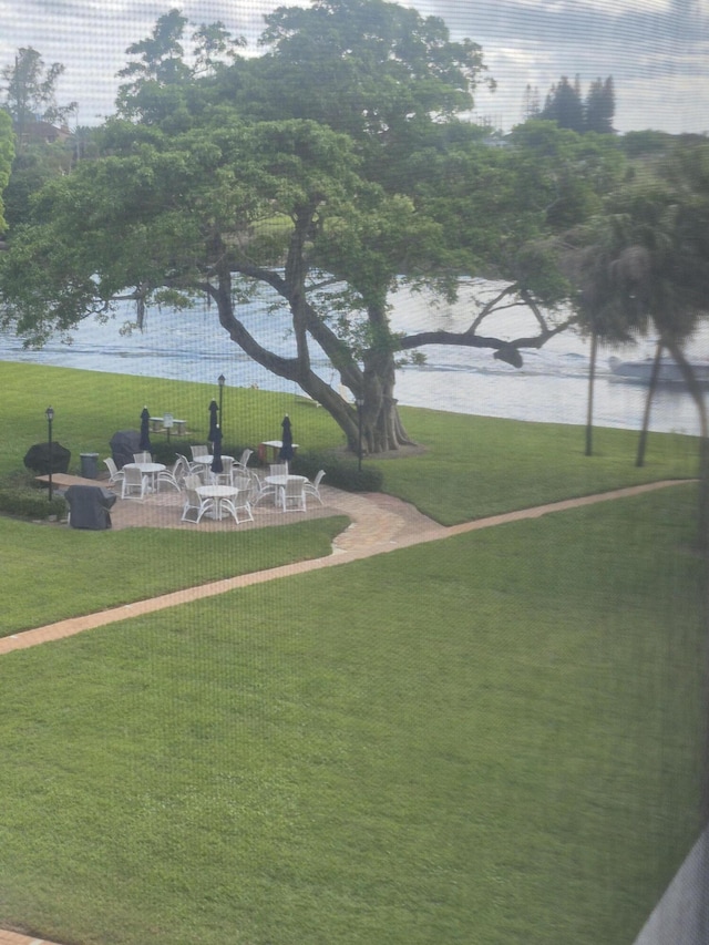 view of community with a water view and a yard