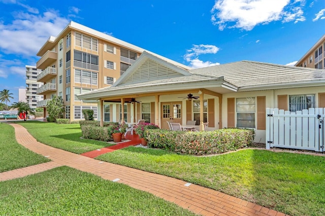 308 Golfview Rd Unit 407, North Palm Beach, FL 33408 - rear view of house featuring ceiling fan, a lawn, and stucco siding