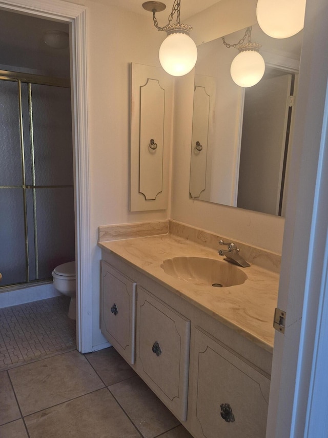 bathroom with a stall shower, tile patterned flooring, vanity, and toilet