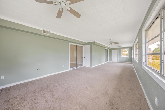 carpeted empty room featuring visible vents, baseboards, and a ceiling fan