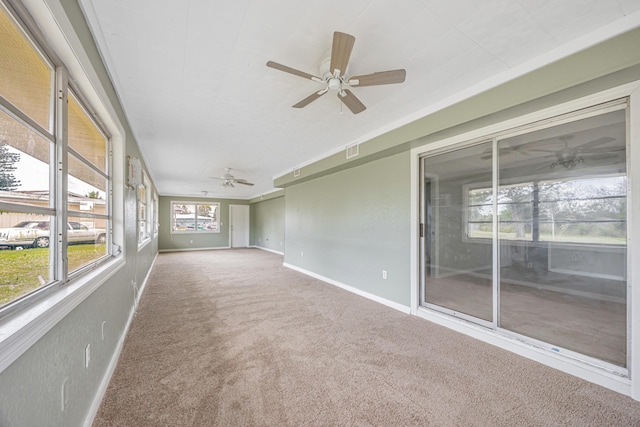 unfurnished sunroom with visible vents and a ceiling fan