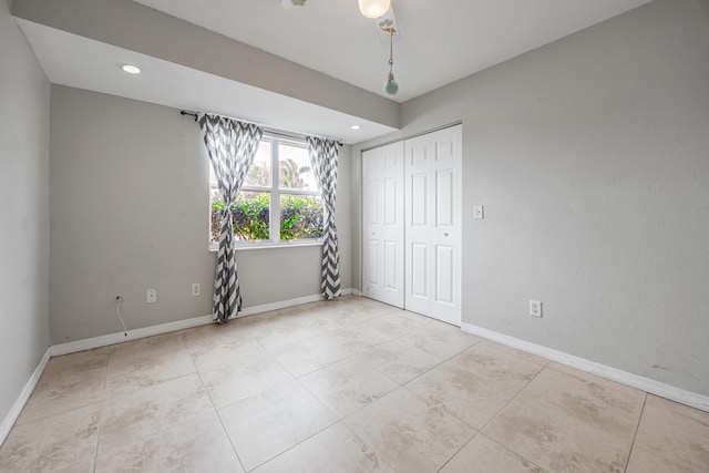 spare room featuring recessed lighting, light tile patterned flooring, and baseboards