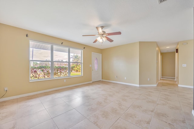 unfurnished room featuring light tile patterned floors, ceiling fan, and baseboards