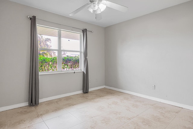 unfurnished room with ceiling fan, baseboards, and light tile patterned floors