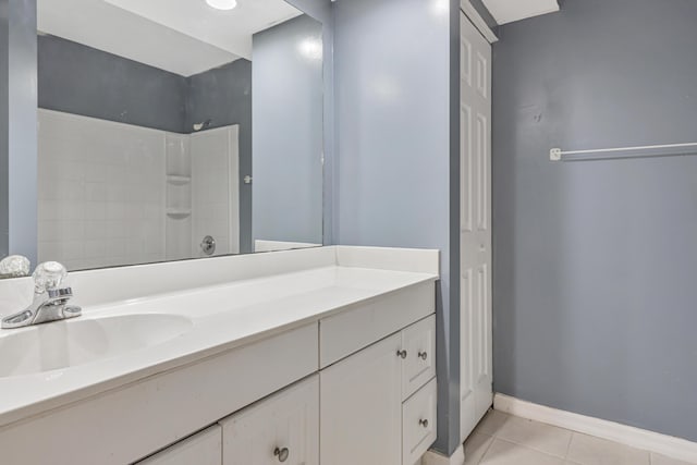 bathroom featuring a closet, tile patterned flooring, vanity, and baseboards