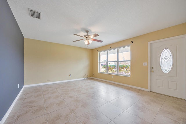 entrance foyer featuring light tile patterned floors, baseboards, visible vents, ceiling fan, and a textured ceiling