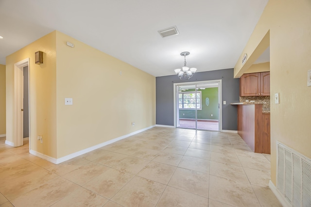 interior space featuring light tile patterned floors, baseboards, visible vents, and an inviting chandelier