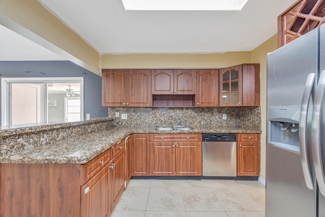 kitchen with stainless steel appliances, dark stone countertops, backsplash, and glass insert cabinets