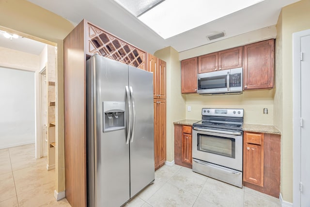 kitchen featuring visible vents, baseboards, appliances with stainless steel finishes, light stone countertops, and light tile patterned flooring