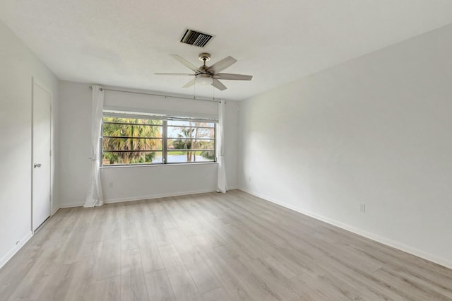 unfurnished room with light wood finished floors, ceiling fan, visible vents, and baseboards