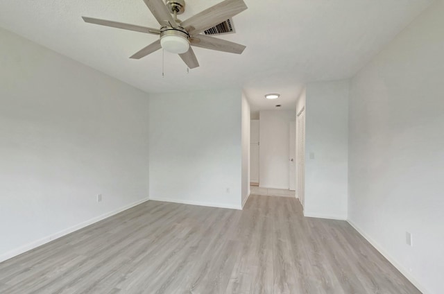 unfurnished room with light wood-style flooring, visible vents, and baseboards