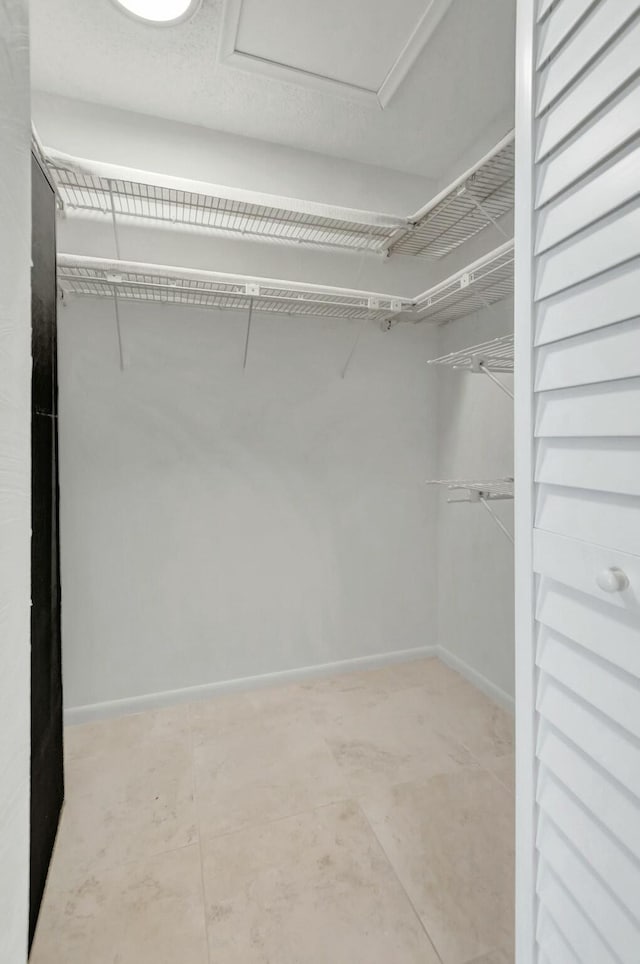 walk in closet featuring attic access