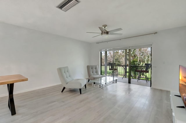 sitting room with light wood finished floors, a ceiling fan, visible vents, and baseboards