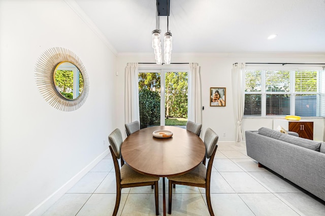 dining space with ornamental molding, a notable chandelier, baseboards, and light tile patterned floors