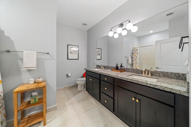 bathroom with double vanity, a sink, and visible vents