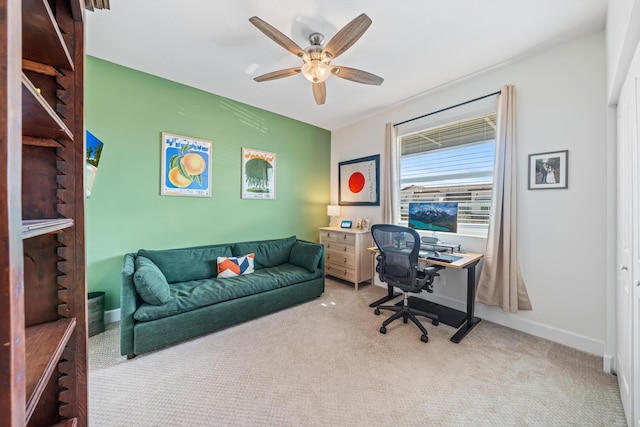 office featuring light colored carpet, ceiling fan, and baseboards