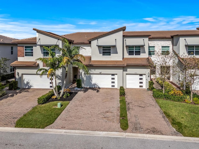 view of front of home featuring a garage, driveway, and stucco siding