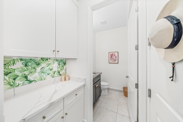 bathroom with tile patterned flooring, toilet, visible vents, vanity, and baseboards