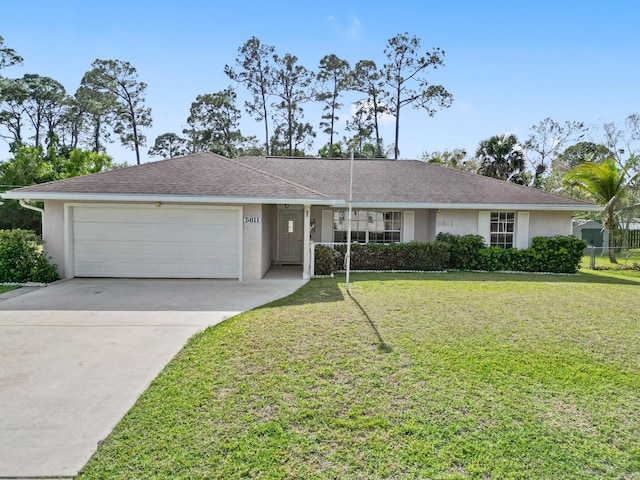 ranch-style home with a garage, driveway, a front lawn, and stucco siding