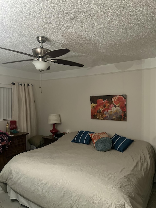 bedroom with a textured ceiling and a ceiling fan