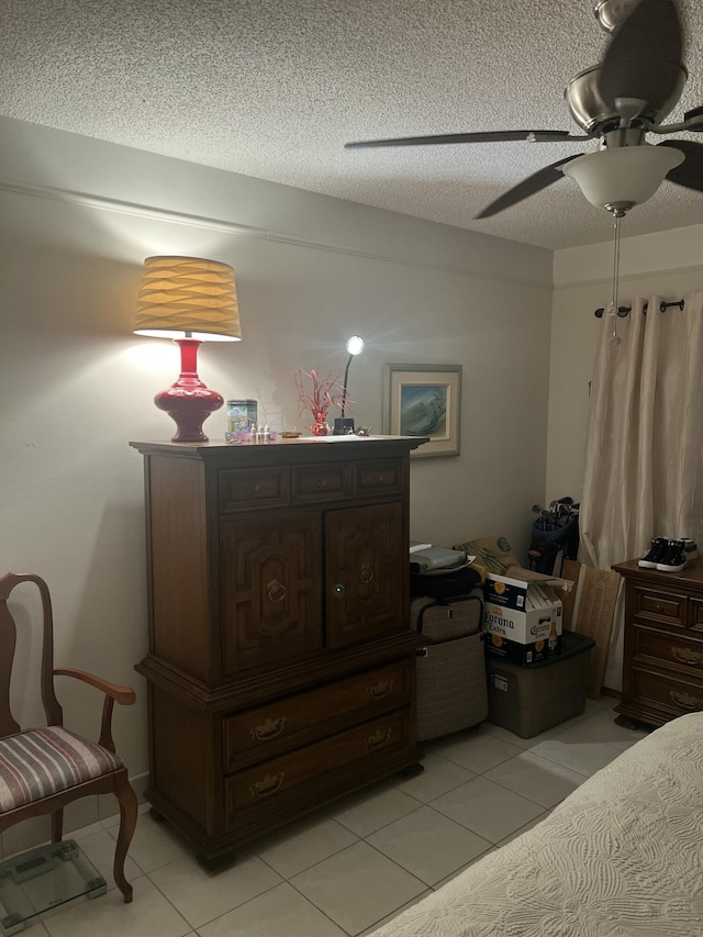 bedroom with a textured ceiling, ceiling fan, and light tile patterned floors