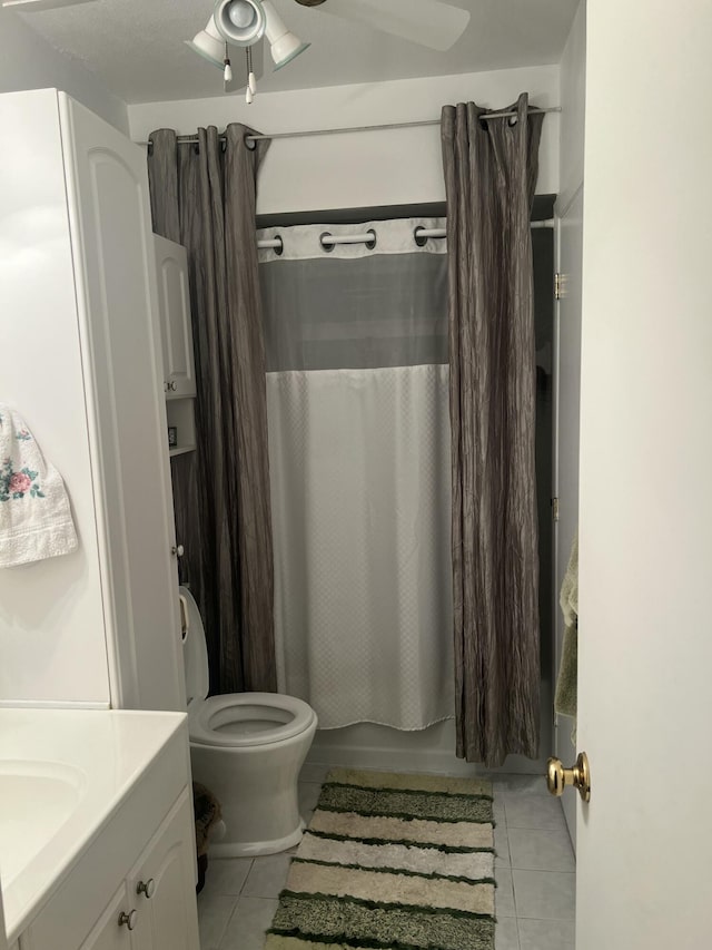 full bath featuring toilet, shower / tub combo, ceiling fan, vanity, and tile patterned floors