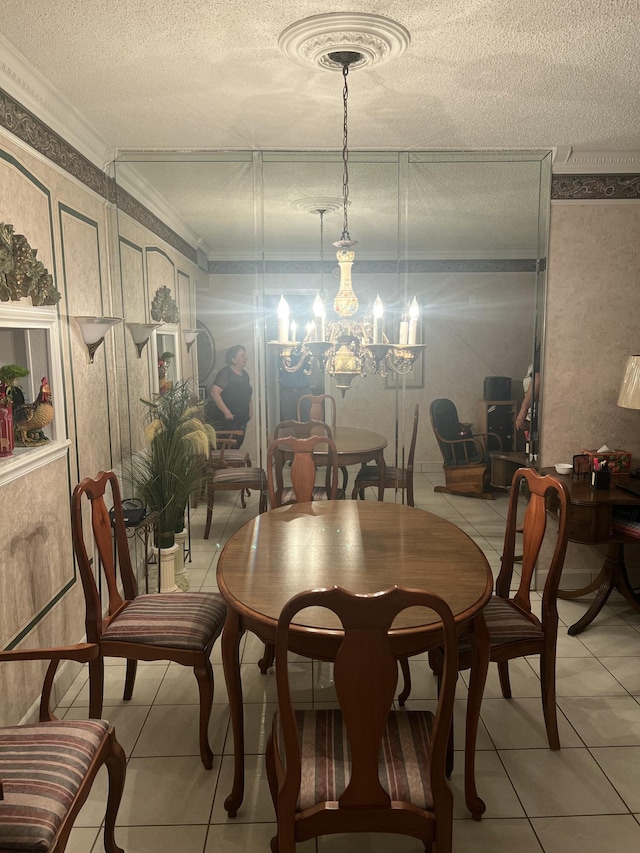 dining space featuring ornamental molding, light tile patterned floors, a textured ceiling, and an inviting chandelier