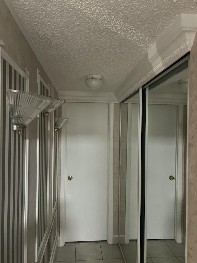 hallway featuring a textured ceiling and light tile patterned floors