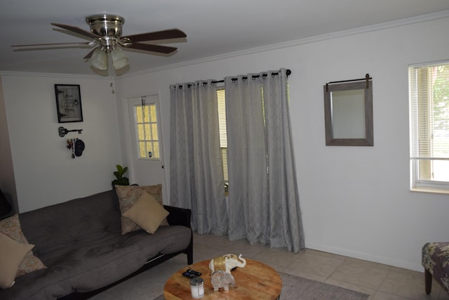 living area with a ceiling fan, baseboards, crown molding, and light tile patterned flooring