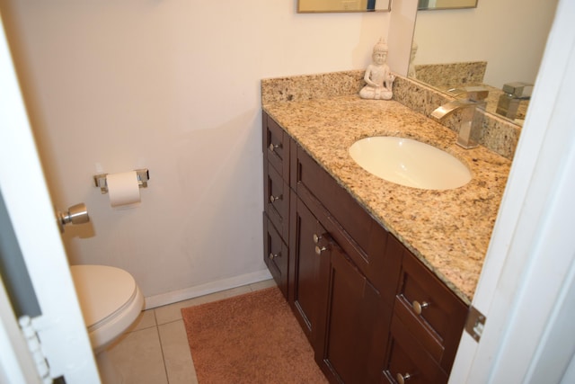 half bath featuring baseboards, vanity, toilet, and tile patterned floors