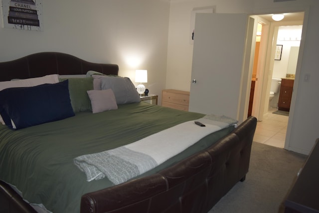 bedroom featuring tile patterned floors, carpet flooring, and ensuite bathroom