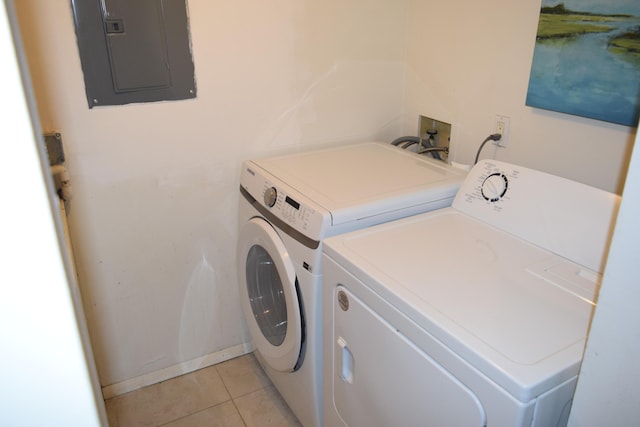 laundry area with laundry area, washer and clothes dryer, light tile patterned flooring, and electric panel