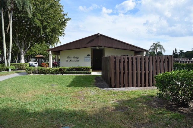 view of side of property with fence and a yard