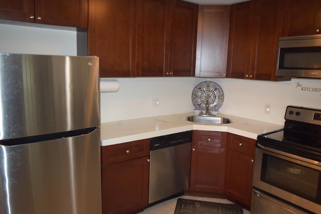 kitchen featuring stainless steel appliances, light countertops, a sink, and light tile patterned floors