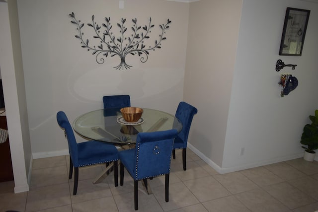 tiled dining area featuring baseboards