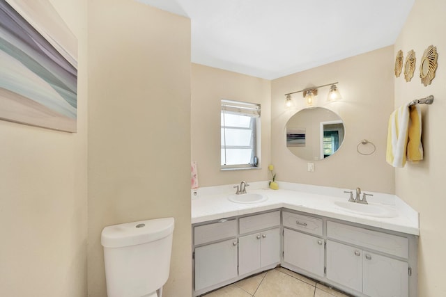 full bathroom with a sink, toilet, double vanity, and tile patterned flooring