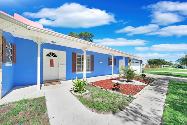 view of front of house with a garage, a porch, and concrete driveway