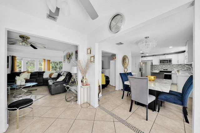 dining area with recessed lighting, light tile patterned floors, ceiling fan with notable chandelier, and visible vents