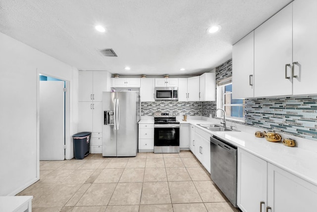 kitchen featuring visible vents, a sink, appliances with stainless steel finishes, light countertops, and decorative backsplash