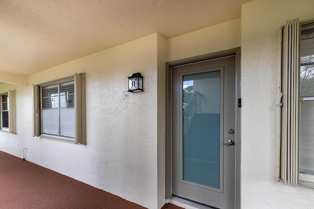 property entrance with stucco siding