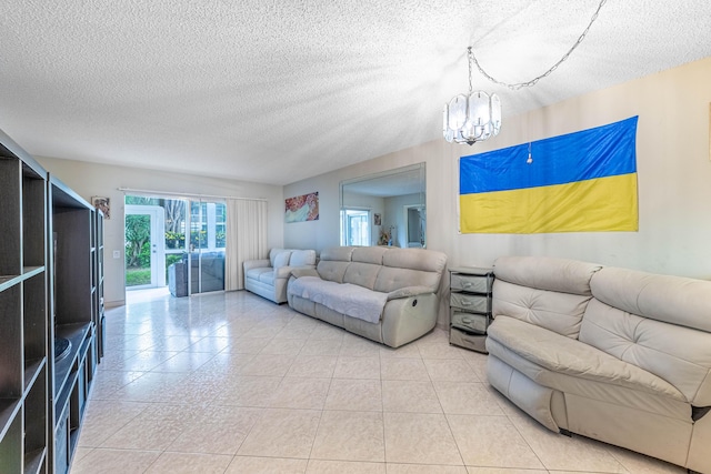 living area with tile patterned flooring, a textured ceiling, and an inviting chandelier