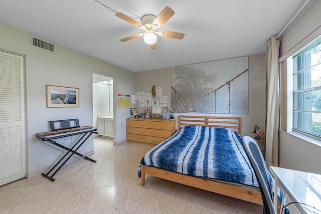 bedroom with light tile patterned floors, multiple windows, visible vents, and a textured ceiling