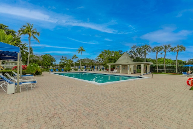 pool with a patio and fence