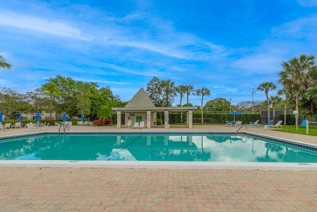 pool with a patio area and fence