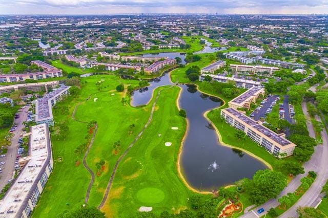 drone / aerial view with a water view and golf course view