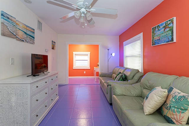 living area with ceiling fan, visible vents, and baseboards