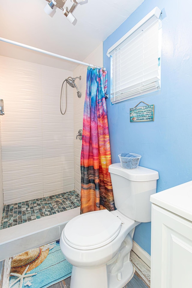 full bath featuring baseboards, a shower stall, toilet, and vanity