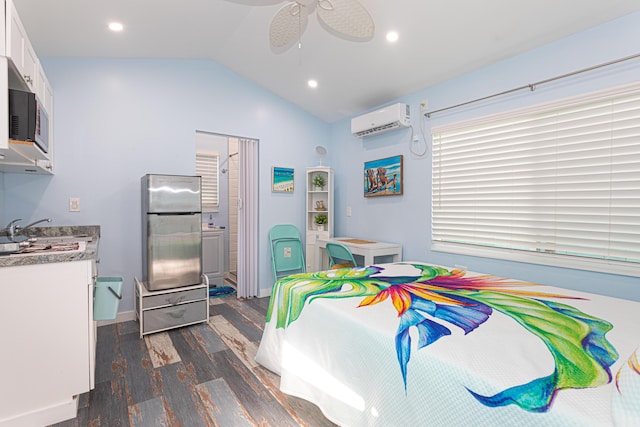 bedroom featuring recessed lighting, vaulted ceiling, an AC wall unit, freestanding refrigerator, and dark wood finished floors