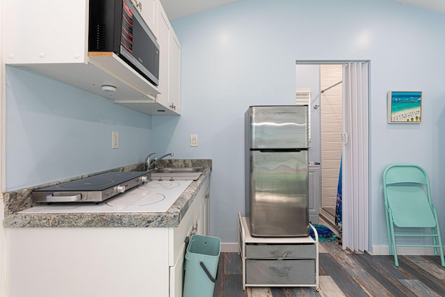 kitchen featuring appliances with stainless steel finishes, a sink, dark wood finished floors, and white cabinets