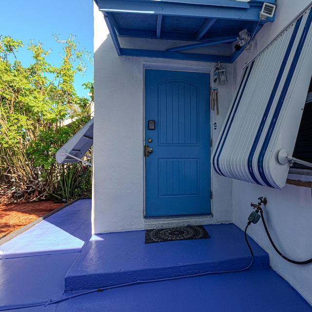 doorway to property featuring stucco siding